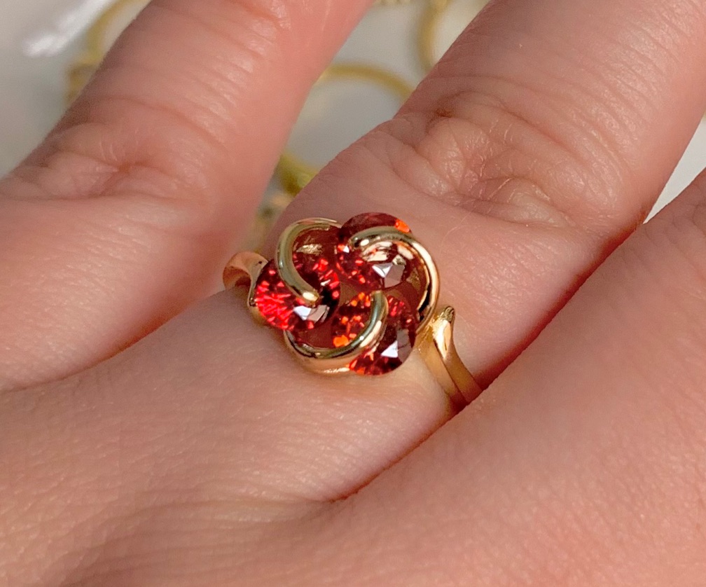 Anillo dorado con 3 cristales de circo a roja