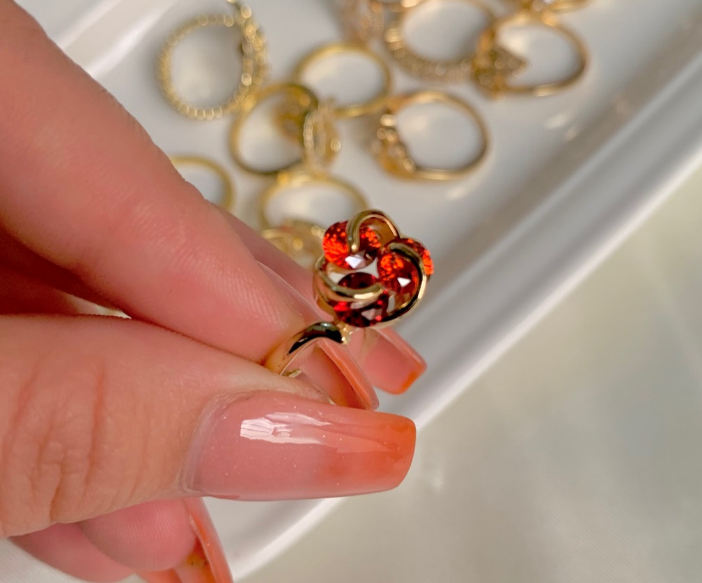 Anillo dorado con 3 cristales de circo a roja