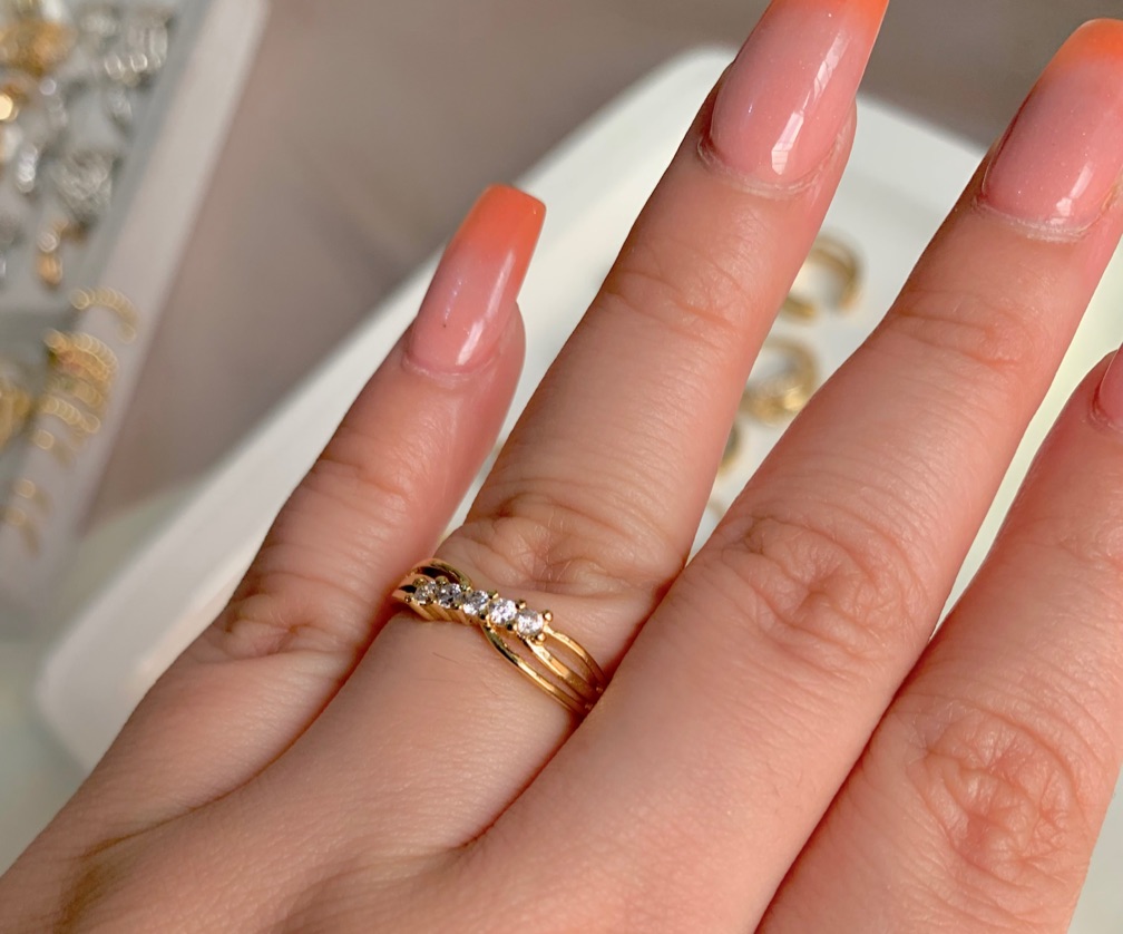 Anillo dorado entrelazado con 5 circona