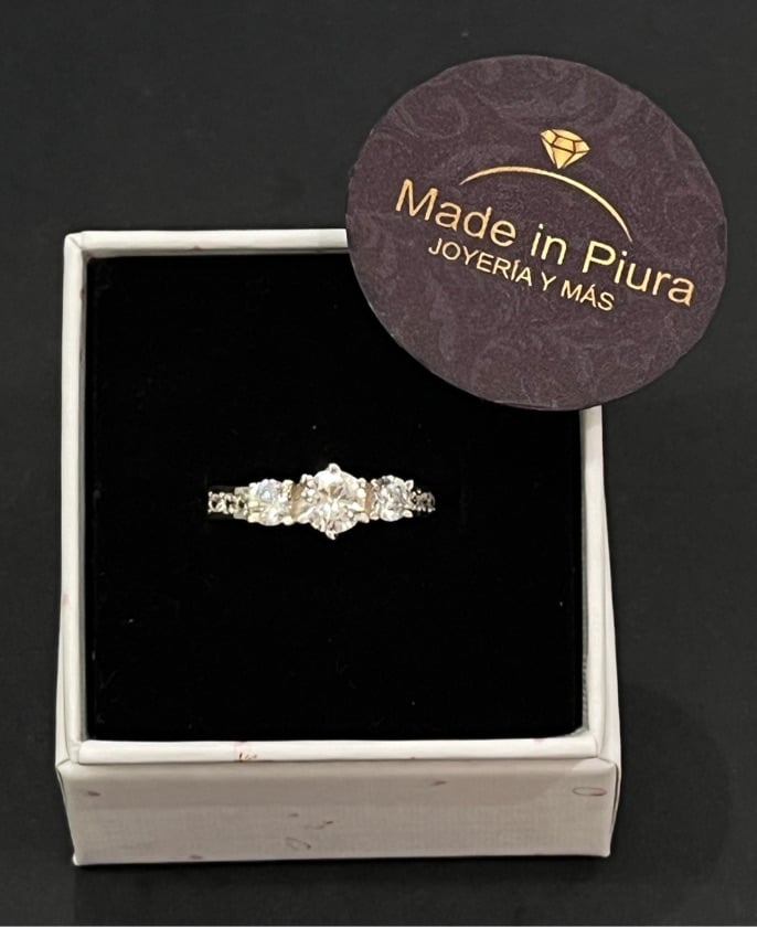 Anillo compromiso 3 piedras grandes ,en medio y pequeñas en los laterales.
