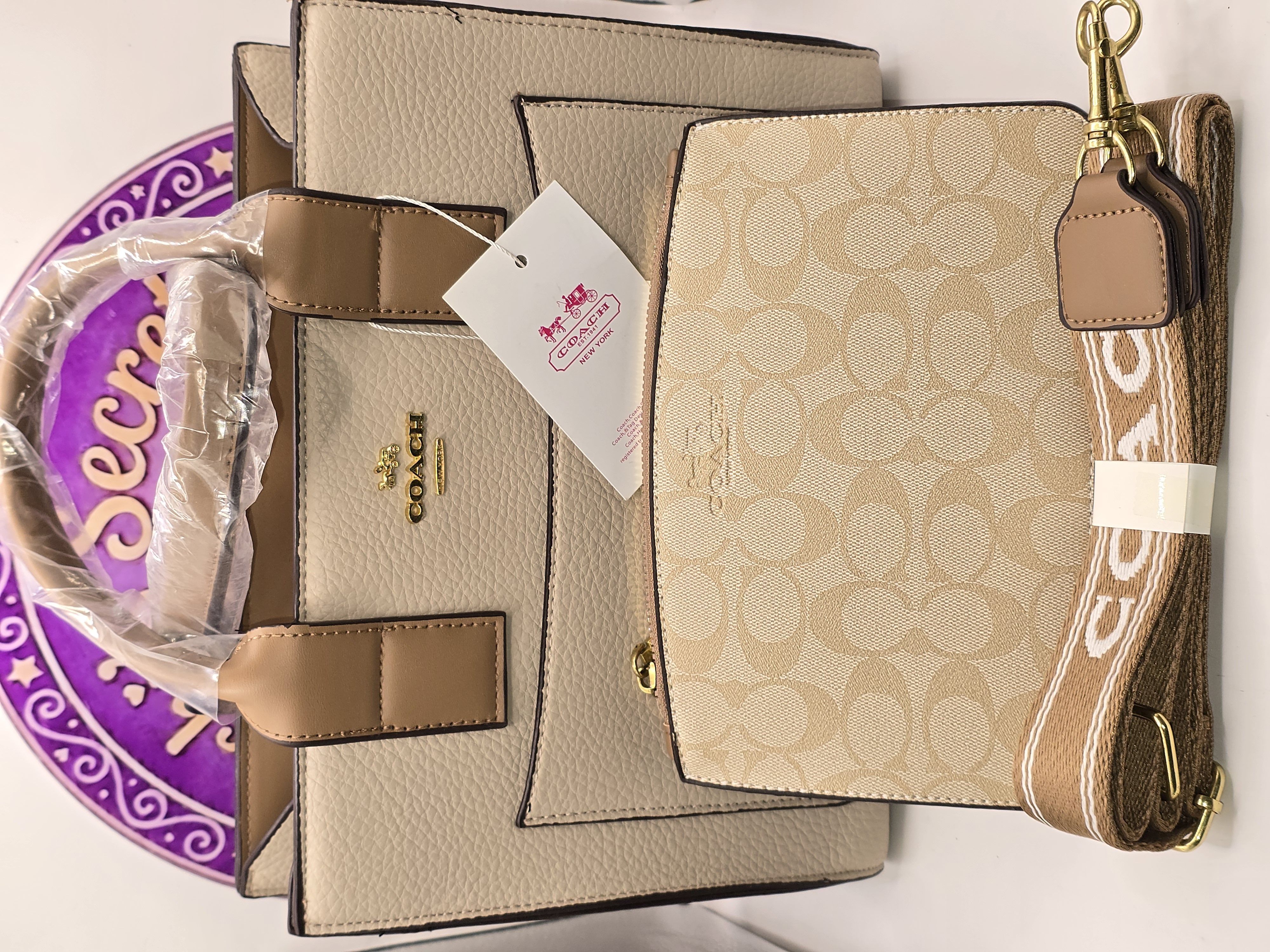 Bi14 Bolsa Coach Beige con vivos color camello. Incluye muñequera y strap para usar como crossbody